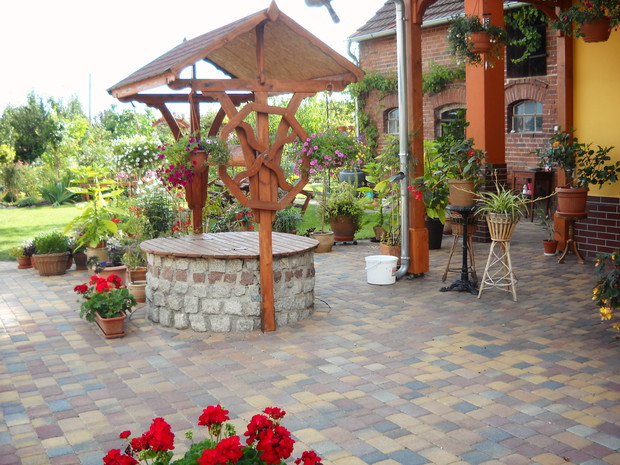 Studnia w otoczeniu donic z kwiatami.