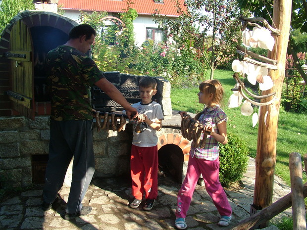 Wnuki pomagające dziadkowi w wędzeniu