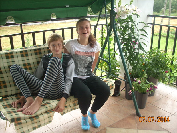 Córki miło spędzają czas na balkonie.