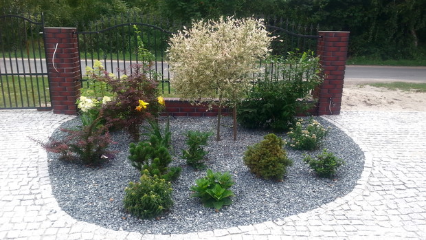 Małe rabaty w półokręgu, zapraszają do domu.