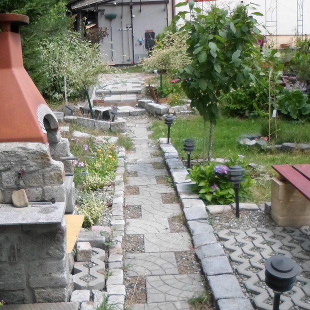 Ścieżka prowadząca z tarasu ogrodowego do rzeczki  w rejonie grilla i ławeczki.