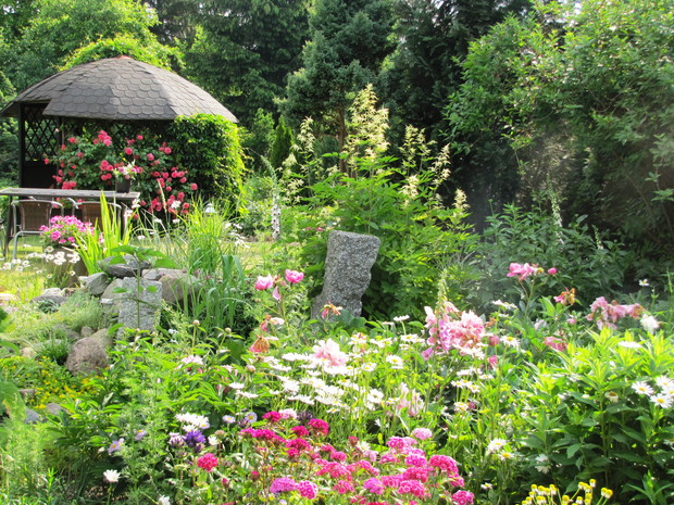 Fragment ogrodu w tle z małą altanką.