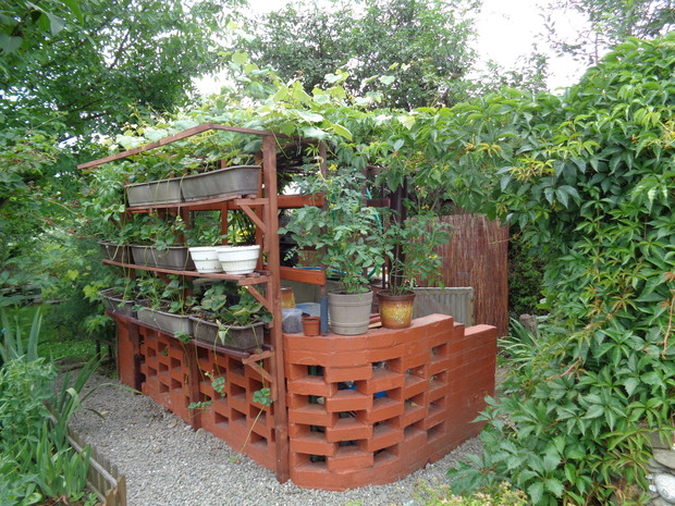 Kompostownik z miejscem do różnych robót ogrodowych i osłona z maty wiklinowej.