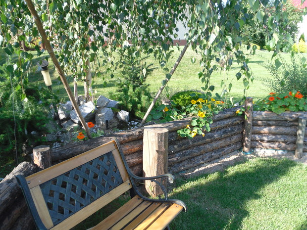 Ławeczka czytelnika przy skalniaku.