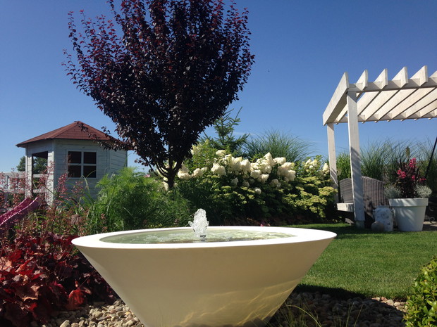 Z niższej perspektywy poza szpalerem z hortensji ciurkadełko