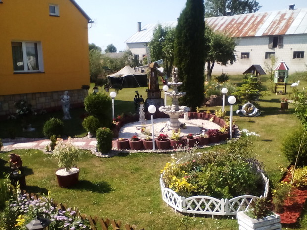 Fontanna wśród gazonow z begonia i zurawka
