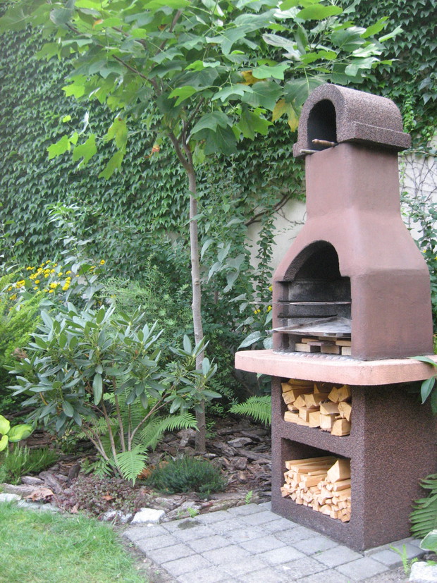 Grill ogrodowy w cieniu tulipanowca oraz różanecznik