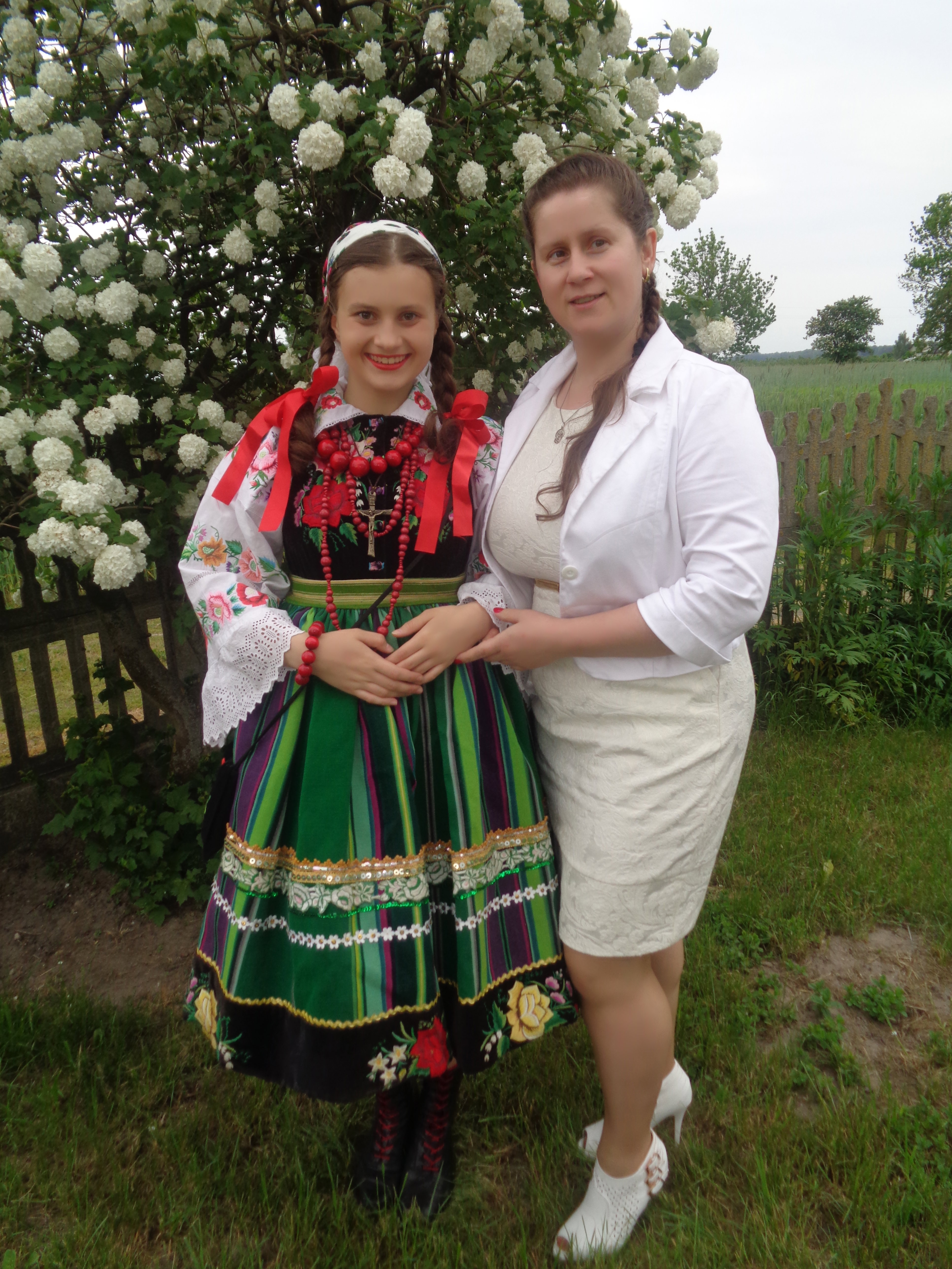 Córka Natalia w stroju regionalnym z siostrą Ewą pod przeszło 30-letnią kaliną . 