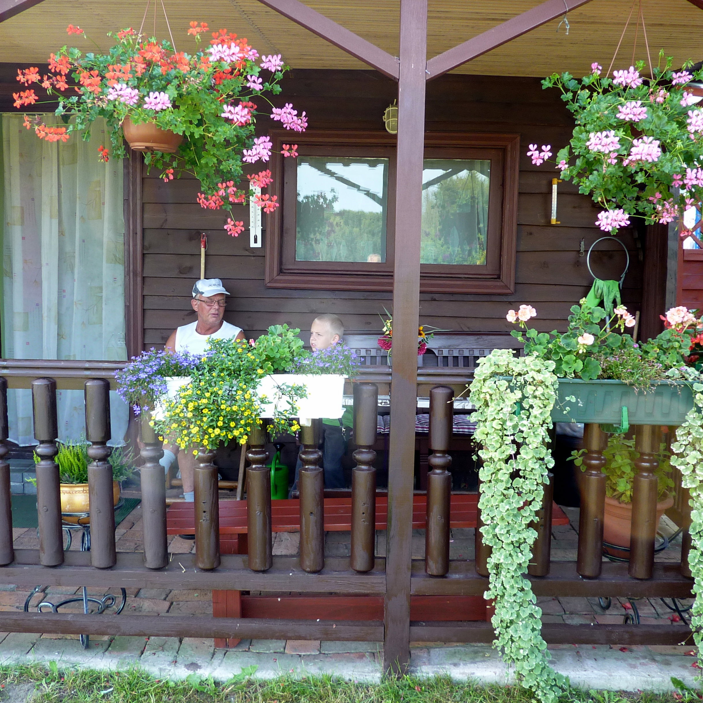 Nasz skromy domek. Mój mąż i wnuczek na werandzie.