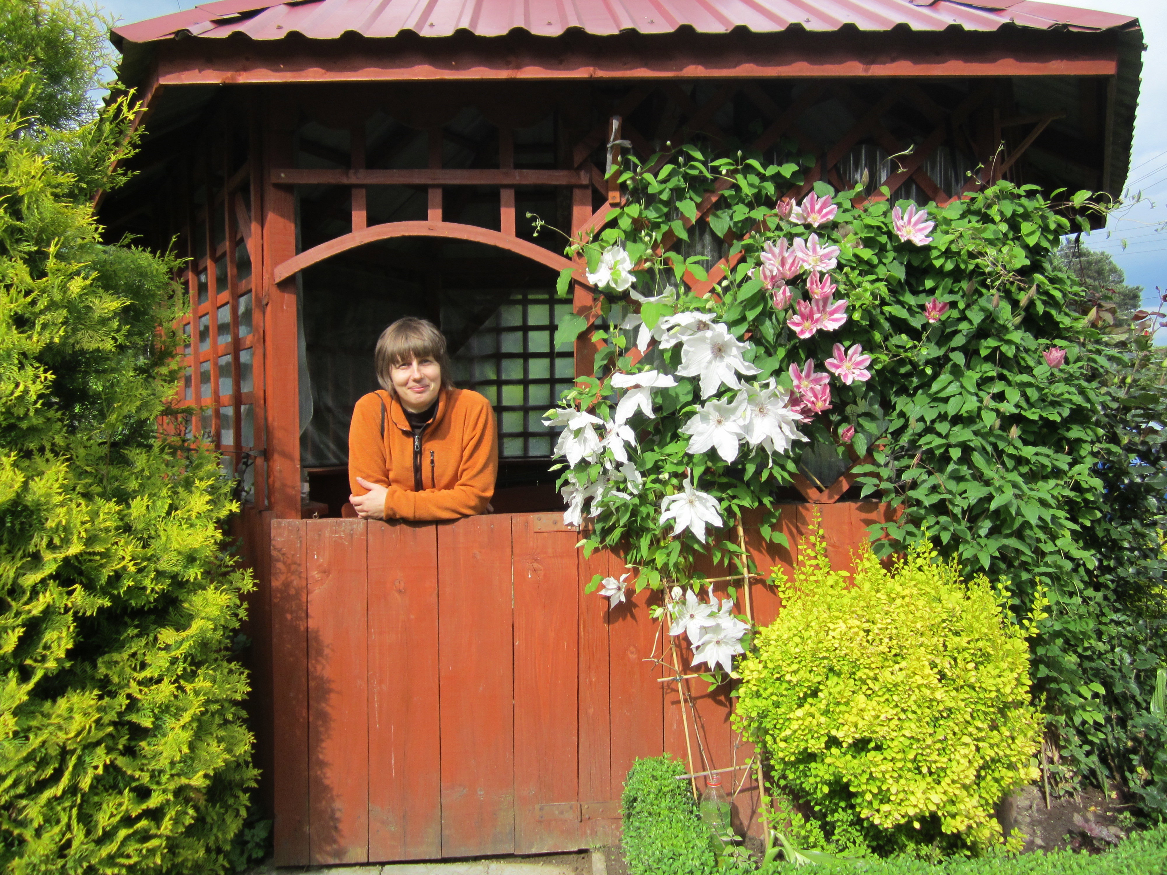 Moja siostra w  altance koło ogrodu wśród kwiatów.