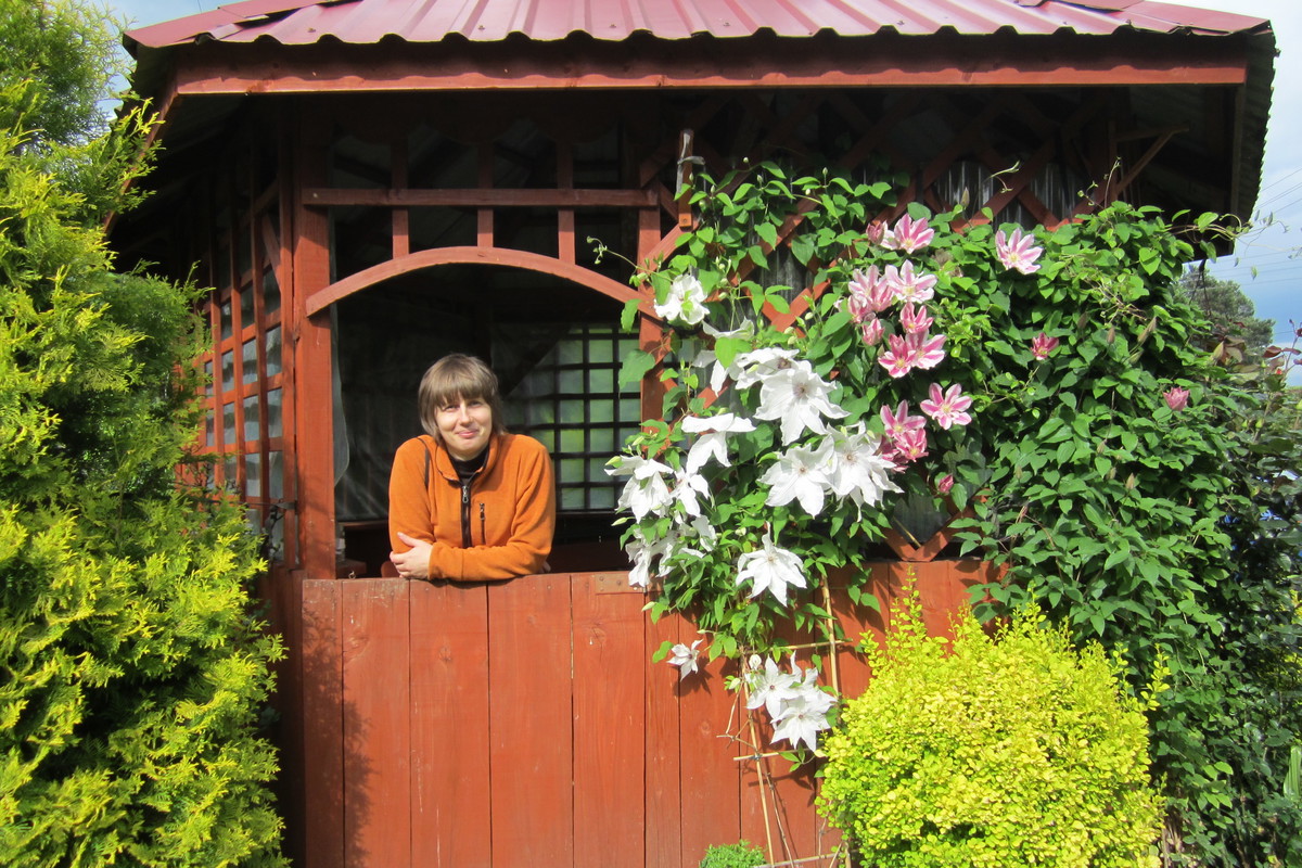 Moja siostra w altance koło ogrodu wśród kwiatów.
