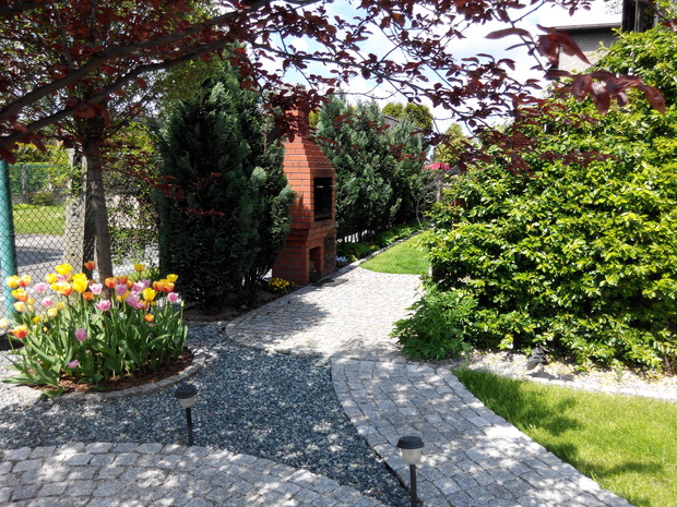 Chodnik z granitu prowadzi do tylnej części ogrodu.