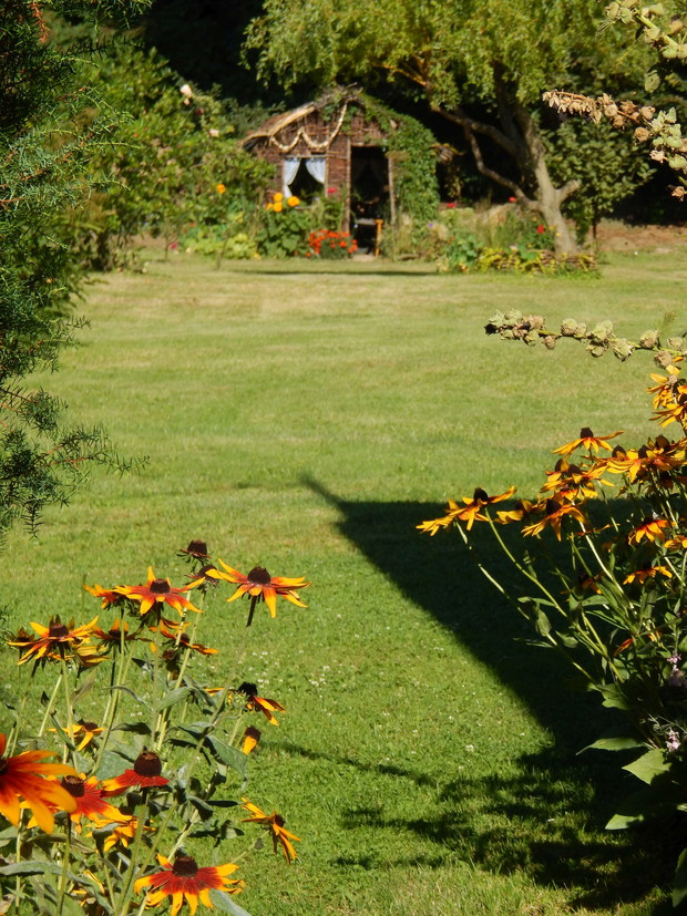 Wracając na ścieżkę pod domem wyłania się podwórze...sporo trawnika...i na krańcu podwórza chatka dla dzieci...