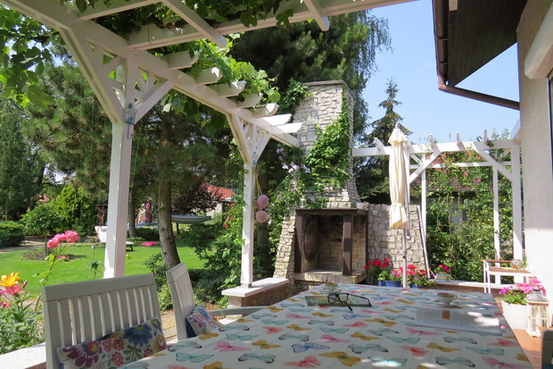 Letni salon. Schowane pod pergolą, okryte winoroślą miejsce na posiłki i spotkania przyjaciół. I oczywiście na kontemplację. Jesienią, zwisające z pergoli grona przynoszą nastrój greckiej tawerny. 