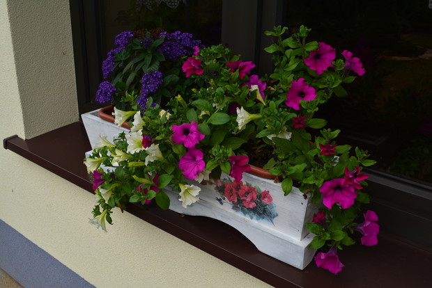 Letnia kompozycja w drewnianej ręcznie wykonanej i ozdobionej donicy