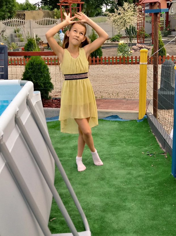 Wygłupy córci na placu zabaw ( w tle ogród )