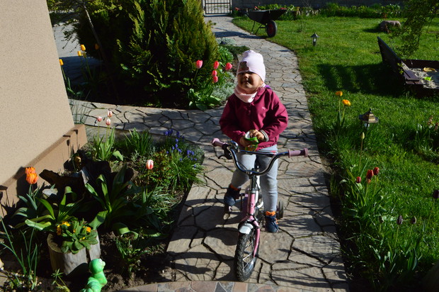 Klaudia ma wygodny podjazd aby po podwórku jeździć na rowerku