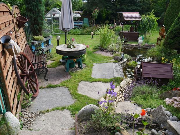 oczko wodne z ławeczką i stolikiem w postaci dawnego koła młyńskiego