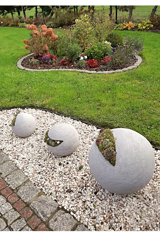 Przedogródek to uporządkowane rabaty z rozchodnikami posadzonymi w betonowych kulach i żurawkami spinającymi całość. Trzeba dobrze reprezentować całość.