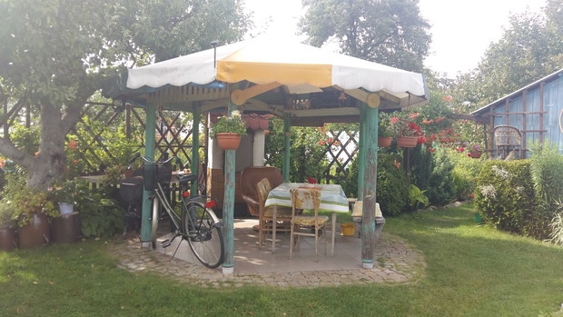 Natomiast reszta rodzinny z ukojeniem korzysta z altanki, aby schować się w cieniu i zrelaksować w otoczeniu pięknych roślin.