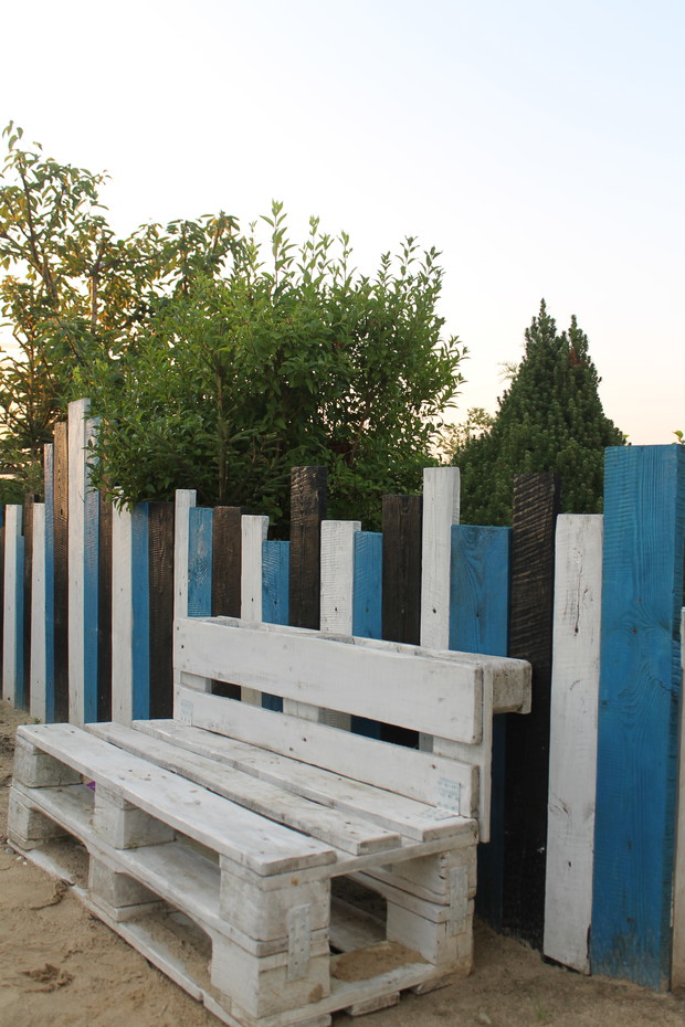 Samodzielnie wykonany płot z desek pobudowlanych w barwach plaży w Normandii