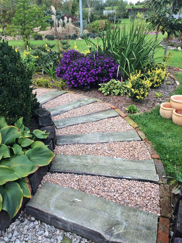 Fragment ogrodu ze ścieżką z podkładów kolejowych i kamieniem