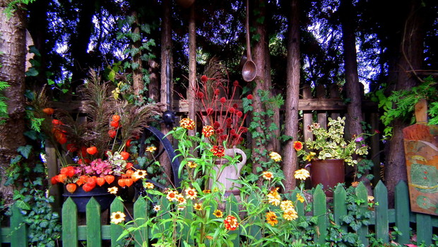 różne kwiaty w pojemnikach vis a vis drzwi wejściowych