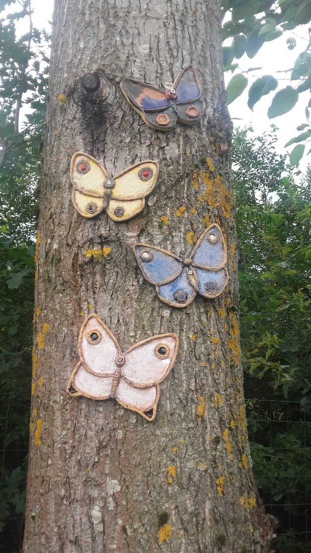 Na topoli ceramiczne, własnoręczne wykonane motyle