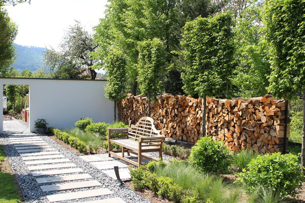 Część ogrodzenia zrobiona jest z drewna kominkowego