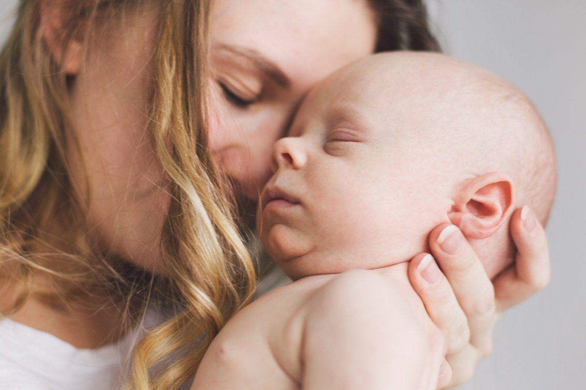 Zmęczona świeżo upieczona mama i noworodek