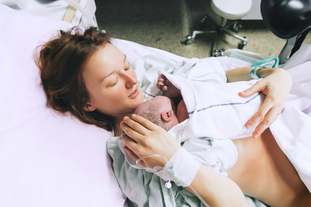 Młoda mama na porodówce z noworodkiem