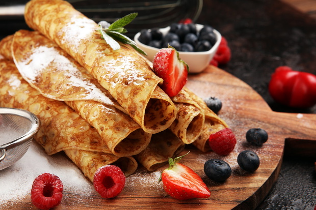 Delicious Tasty Homemade crepes or pancakes with raspberries and mint.
