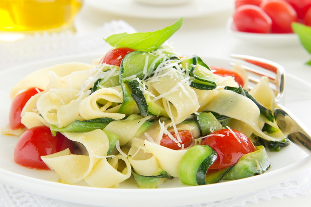 Pasta tagliatelle with zucchini and tomatoes.