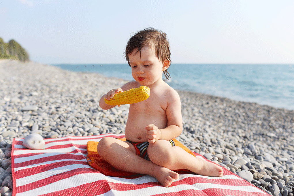 dziecko na plaży, jedzące dziecko