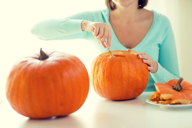 close up of woman with pumpkins at home