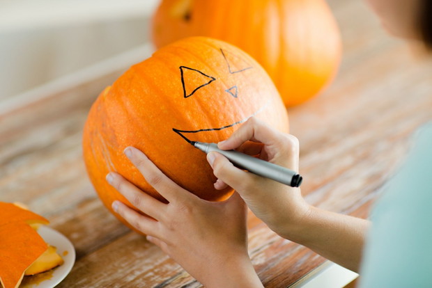 close up of woman with pumpkins at home
