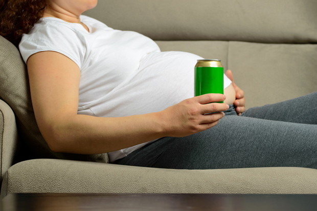 pregnant woman relaxing at home and enjoying a refreshment