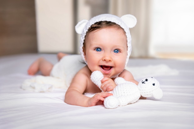 Portrait eines glücklichen, süßen Baby Mädchens mit blauen A