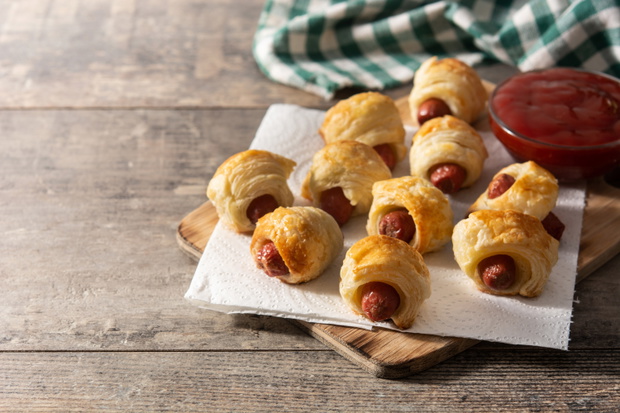 Pigs in blankets. Mini sausages wrapped in puff pastry with ketc