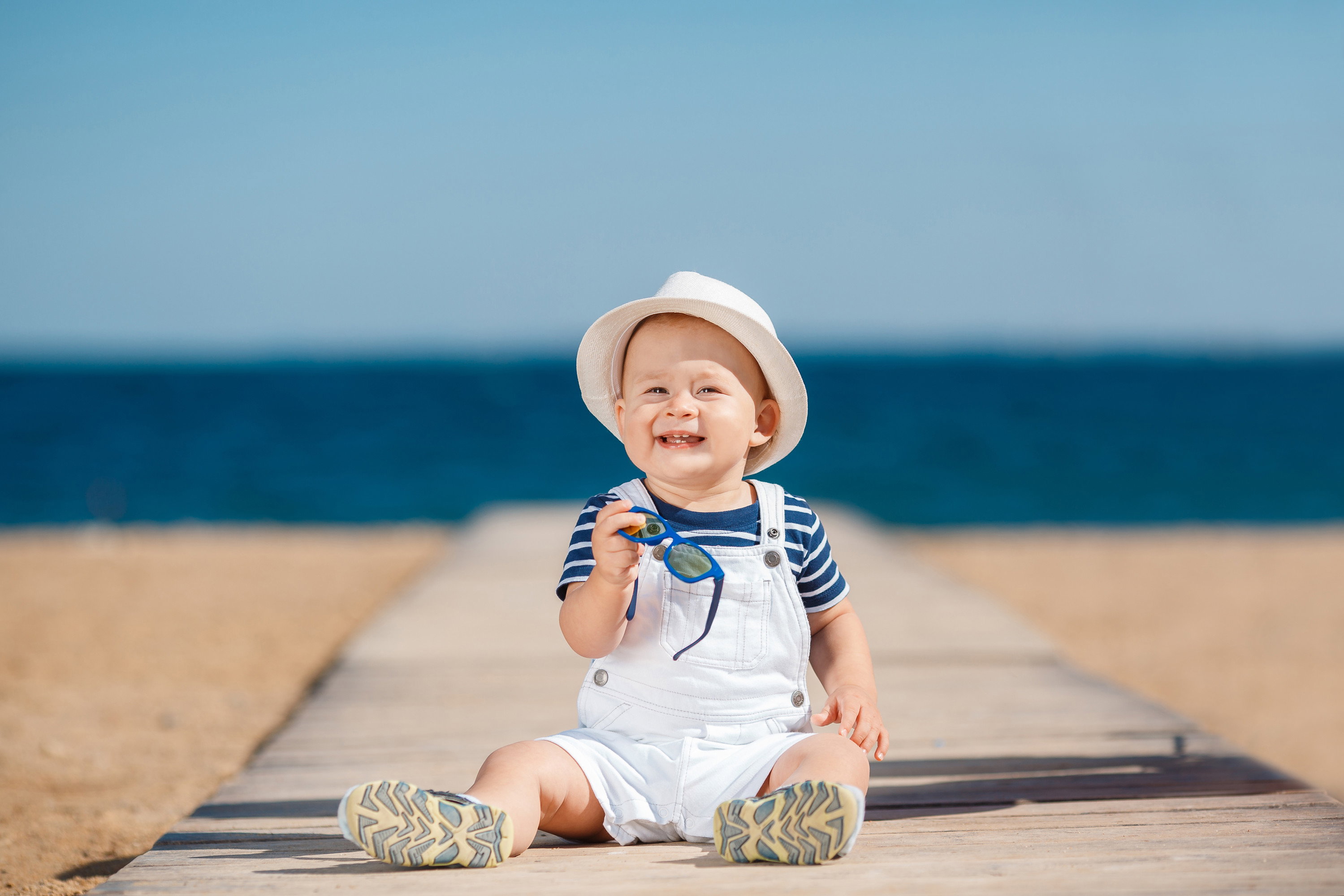 Portrait of a happy child with a hat on the beach