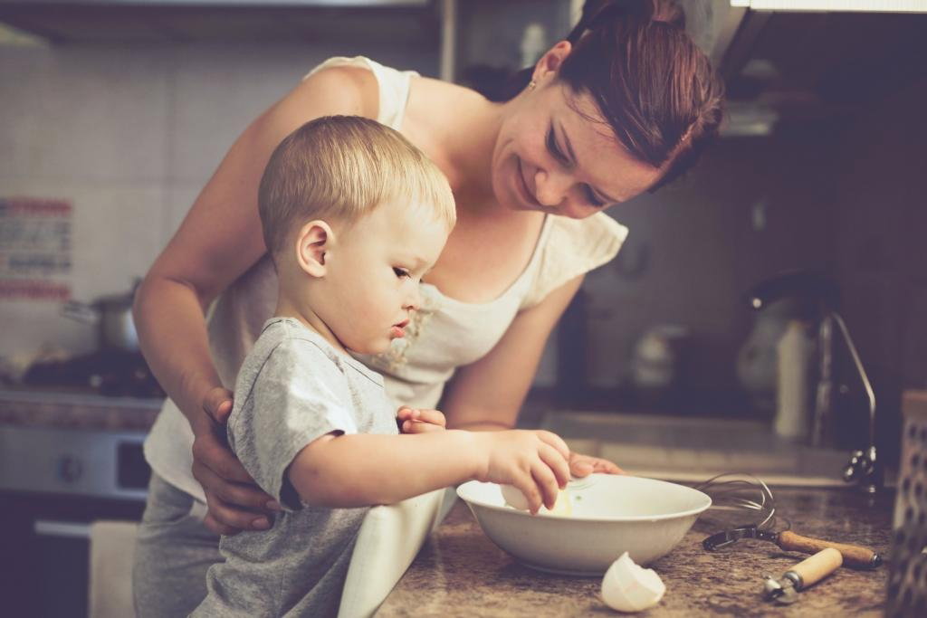 Uśmiechnięta mama gotuje z dzieckiem w kuchni