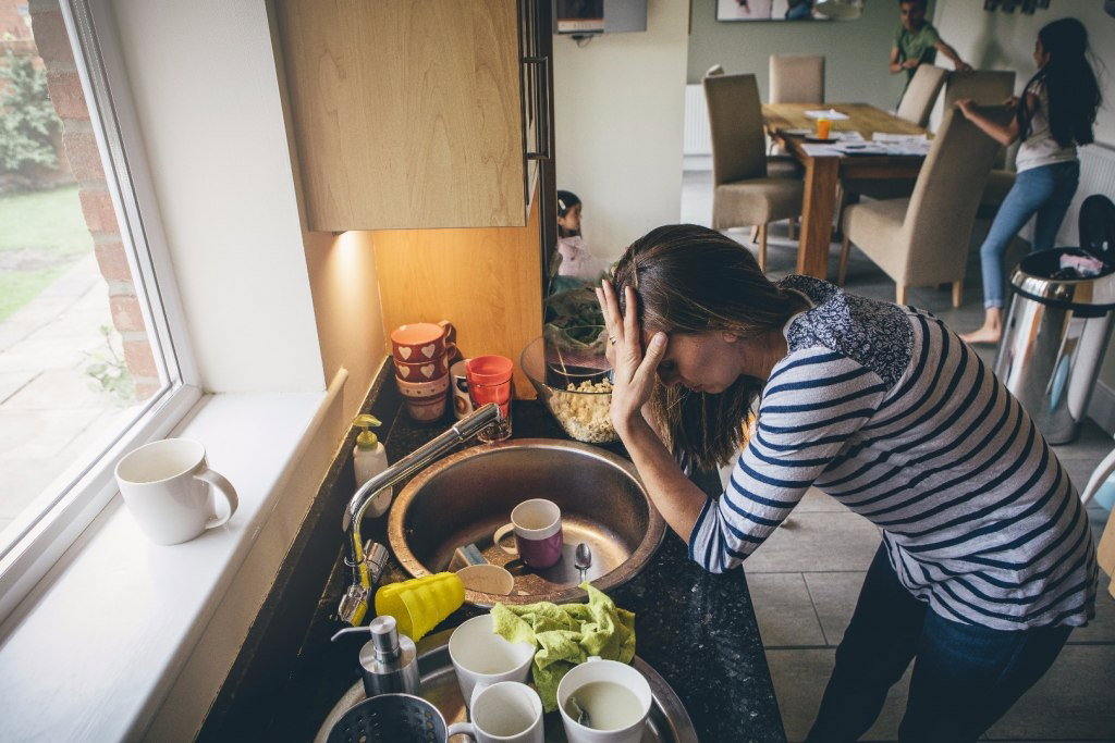 Zmęczona mama zajmuje się domem i dziećmi