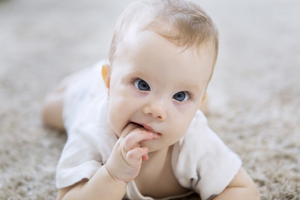 Cute Caucasian girl baby crawling on the carpet