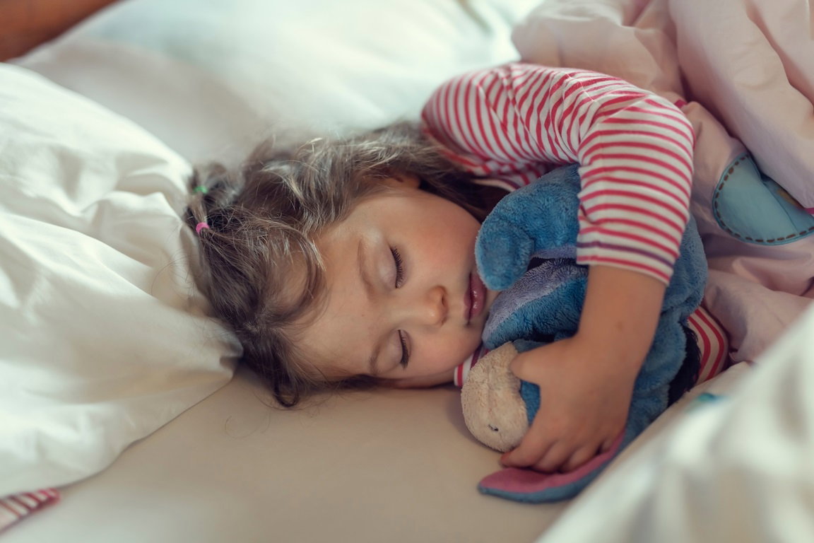 dziewczynka śpi z ulubioną maskotką
