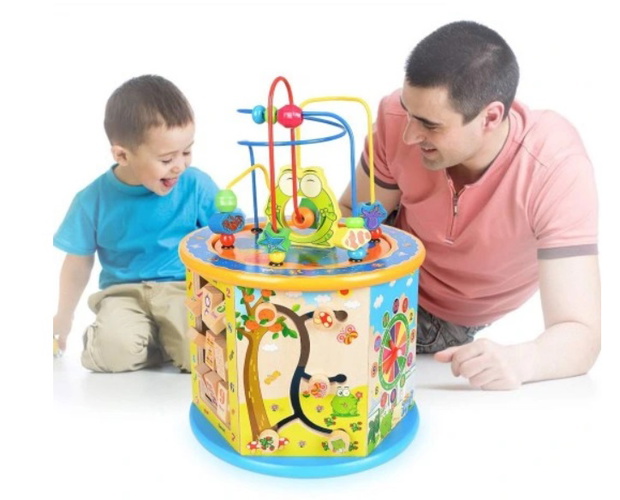 Baby boy playing with wooden toys lying on the Mat. Ecology, education, upbringing concept