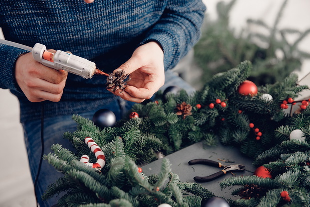 Christmas tree wreath decoration with man hand workshop DIY