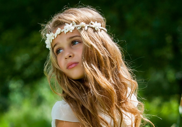 Girl playing with white dress in field.