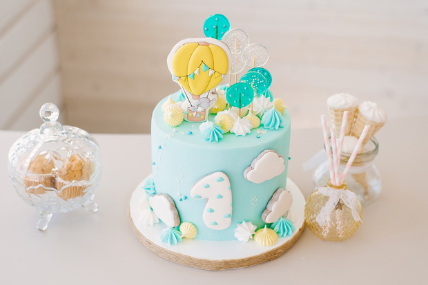 Celebrity background design for birthday celebration with a gourmet cafe, the first year of a baby a single baby. One year birthday party decoration. Beautiful blue cake with gingerbread, meringues and a balloon