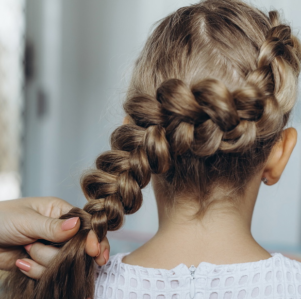 Mother do hair braid to her daughter