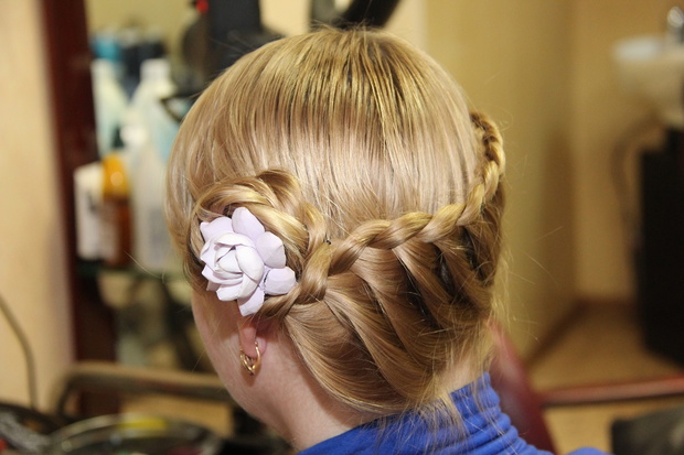 hairstyle with braided pigtails on head of female mannequin. Heart from hair, creative hairstyle on back of dummy. Mannequin's head hairstyle in hairdresser salon. weaving fashionable long braids.